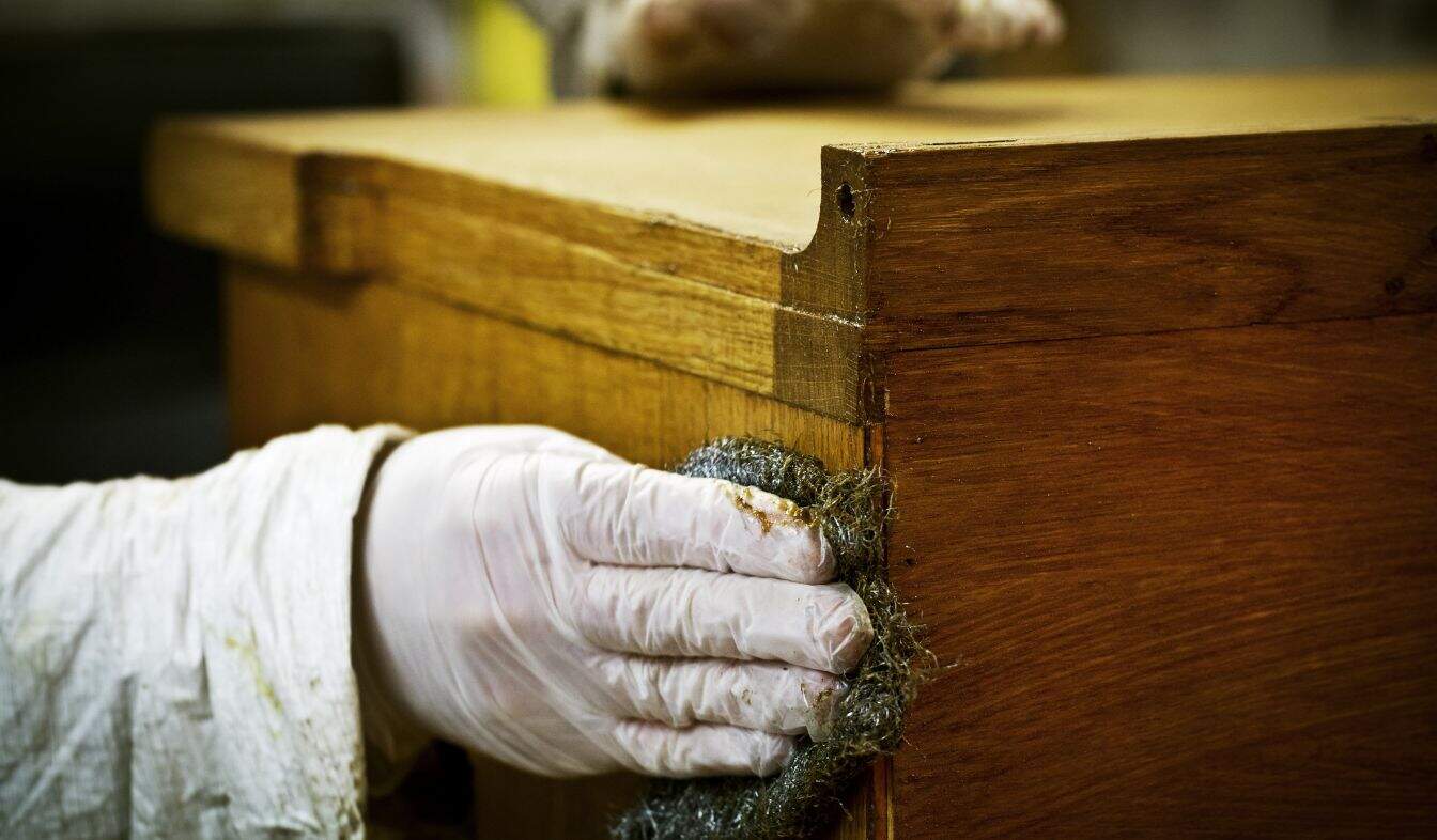 When Should You Consider Cabinet Refinishing a-person-in-gloves-using-wire-wool-to-sand-down-or-2025