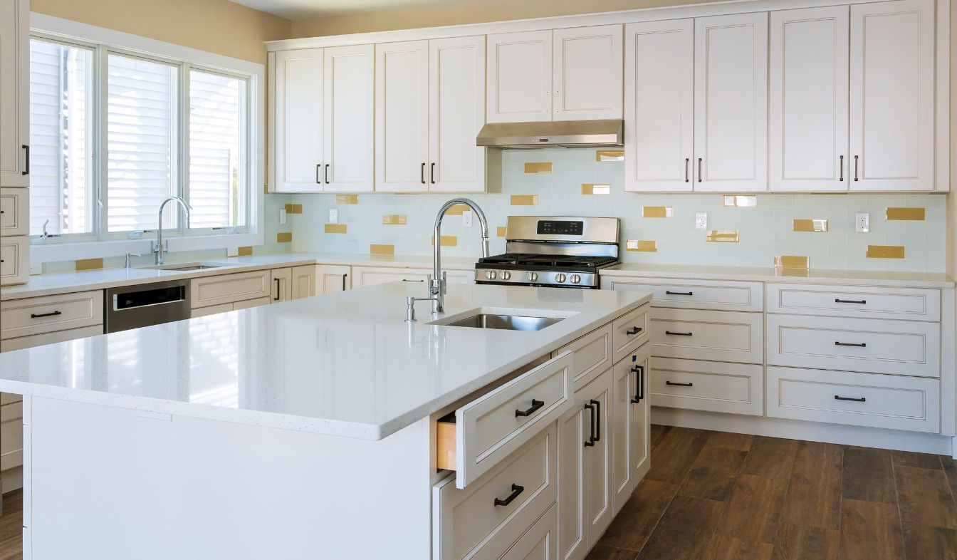Installer fitting cabinets and a countertop in a white kitchen