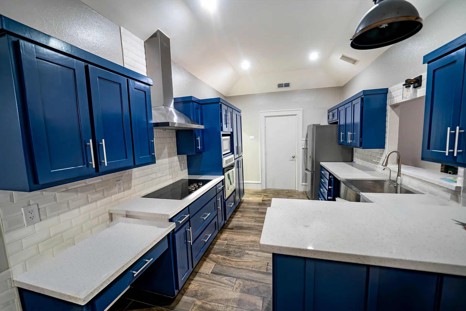 Navy blue refinished kitchen cabinets with white subway tile backsplash