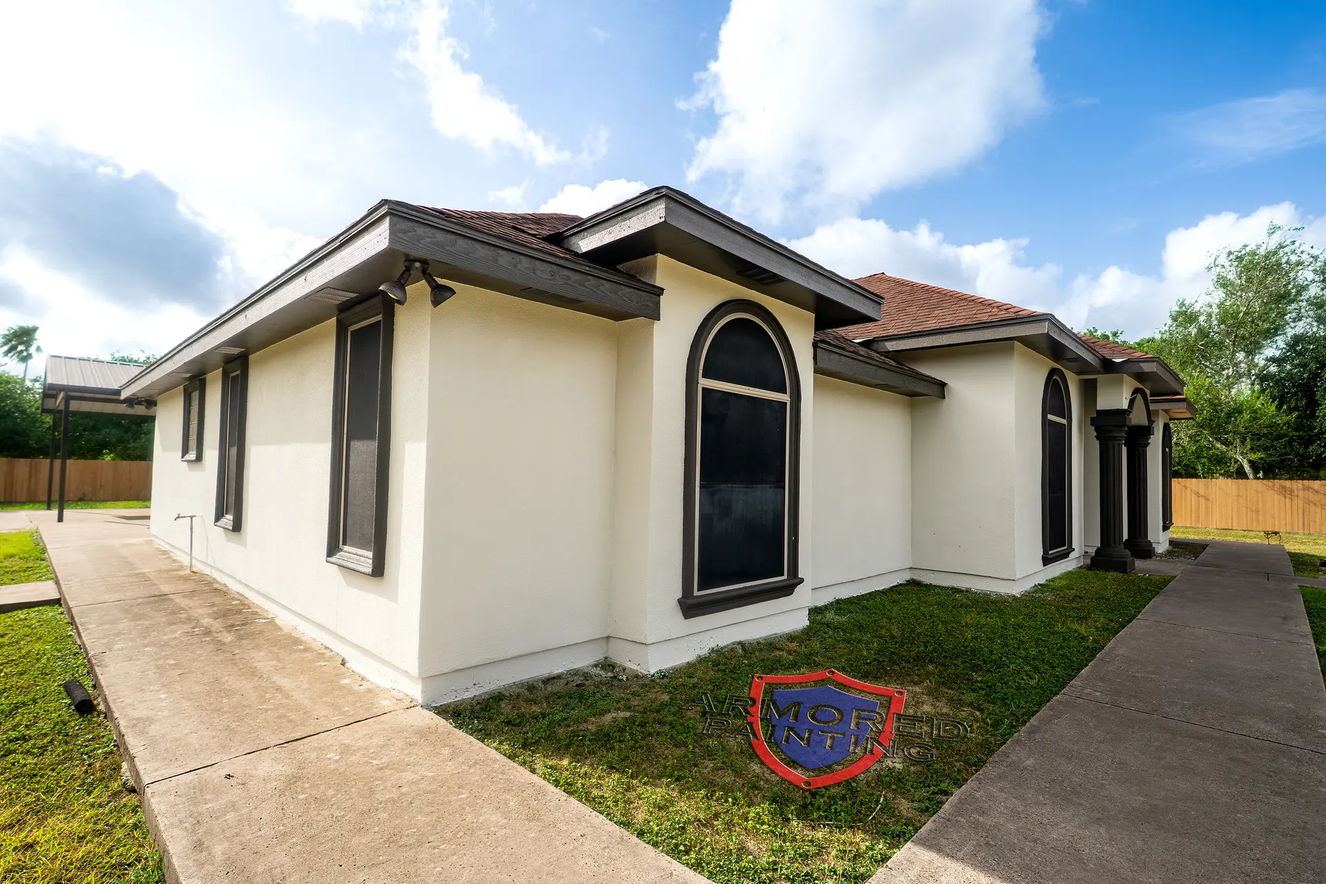 Single-story cream stucco home with arched window after exterior painting