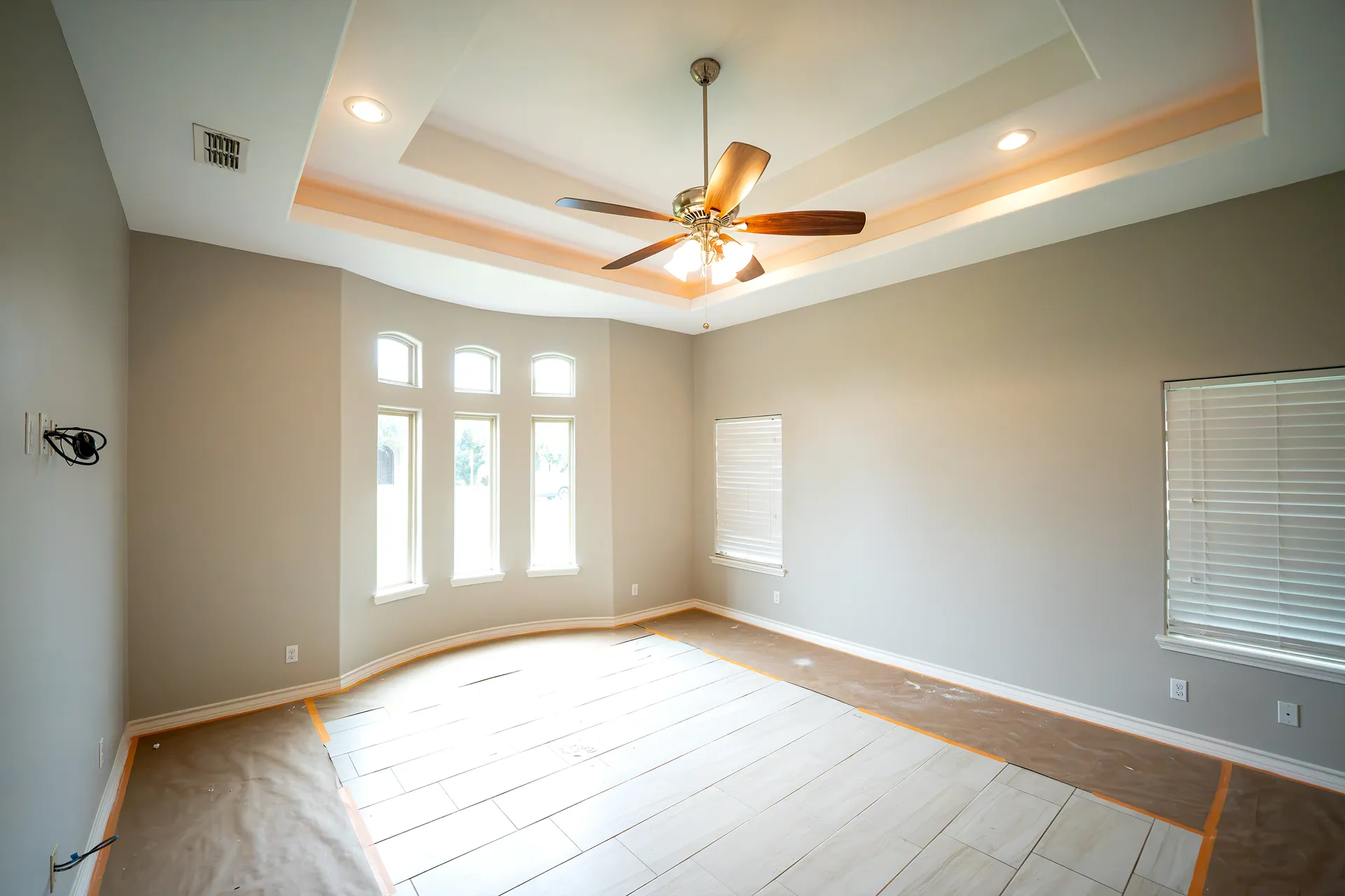 Newly painted bedroom with a tray ceiling and tall windows