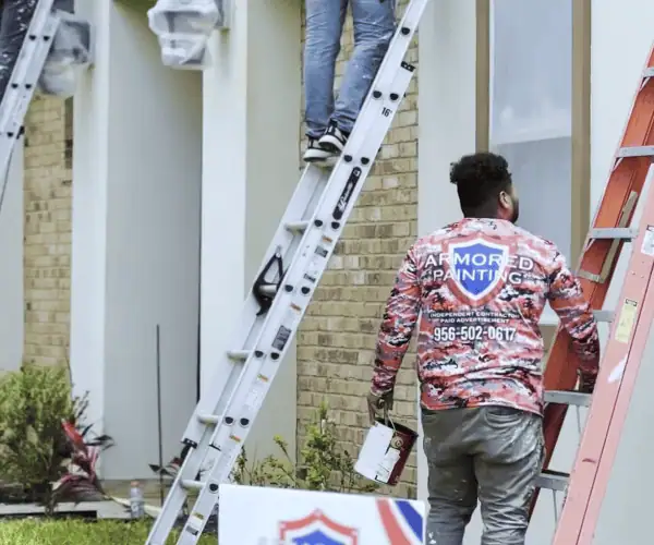 Armored Painting crew on ladders painting a two-storey home exterior